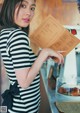 A woman in a black and white striped dress holding a menu.