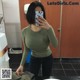 A woman taking a selfie in a public restroom.