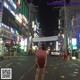 A woman standing in the middle of a busy street at night.