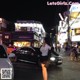 A woman walking down the street at night in a city.