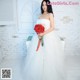 A woman in a wedding dress holding a bouquet of flowers.