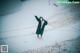 A woman wearing a face mask standing in the snow.