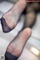 A close up of a person's feet in black stockings.