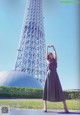 A woman standing in front of a tall tower.