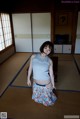 A woman standing on a tatami mat in a room.