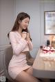 A woman sitting at a table with a birthday cake.