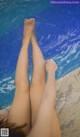 A woman's legs in a swimming pool with water on them.