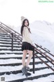 A woman standing on a set of stairs in the snow.