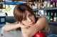 A woman leaning on a counter in front of a bar.