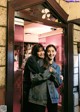 A couple of women standing next to each other in front of a door.