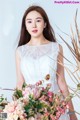 A woman in a white dress holding a bouquet of flowers.