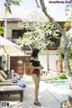 A woman in a bathing suit standing next to a pool.