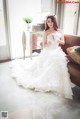 A woman in a wedding dress sitting on a couch.