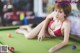 A woman in a red bikini laying on a pool table.