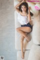 A woman laying on top of a white couch.