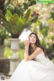 A woman in a wedding dress sitting on a bench.