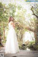 A woman in a wedding dress standing on a wooden bridge.