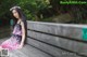 A woman sitting on a wooden bench in a park.