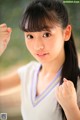 A young woman in a white shirt is posing for a picture.