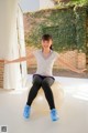 A woman sitting on an exercise ball with her arms outstretched.