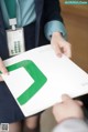 A person holding a book with a green and white logo on it.