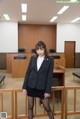 A woman in a business suit standing in a courtroom.