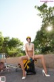 A woman sitting on top of a bike next to a wall.