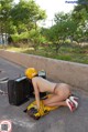 A woman in a yellow helmet is sitting on the ground.