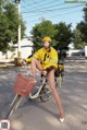 A woman in a yellow raincoat riding a bike.