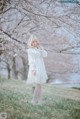 A woman in a white dress standing in a field of flowers.