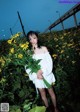 A woman standing in a field of yellow flowers.