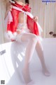 A woman in a red and white lingerie sitting on a bathtub.