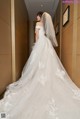 A woman in a wedding dress standing in a hallway.