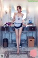 A woman standing in front of a dressing table in a bathroom.