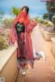 A woman in a red kimono is posing for a picture.