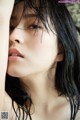 A woman with wet hair is posing for a picture.