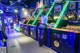 A woman standing in front of a row of arcade machines.